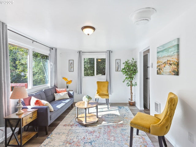 living area featuring wood finished floors, visible vents, and baseboards