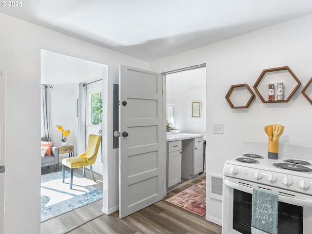 kitchen with dark wood-type flooring, visible vents, electric stove, light countertops, and gray cabinets