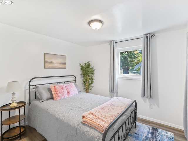 bedroom with wood finished floors and baseboards