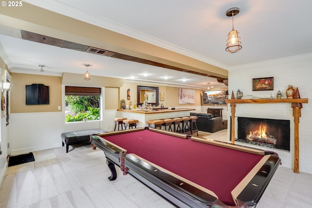 rec room featuring carpet floors, pool table, crown molding, a wainscoted wall, and a lit fireplace