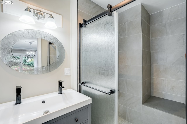 full bathroom featuring a tile shower, vanity, and a chandelier