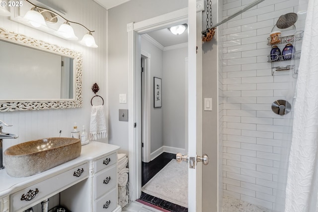 bathroom with a tile shower, crown molding, and vanity