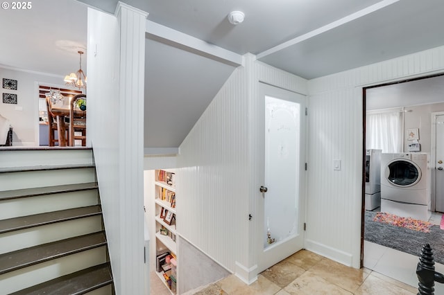 staircase with washer and clothes dryer, tile patterned floors, and a chandelier