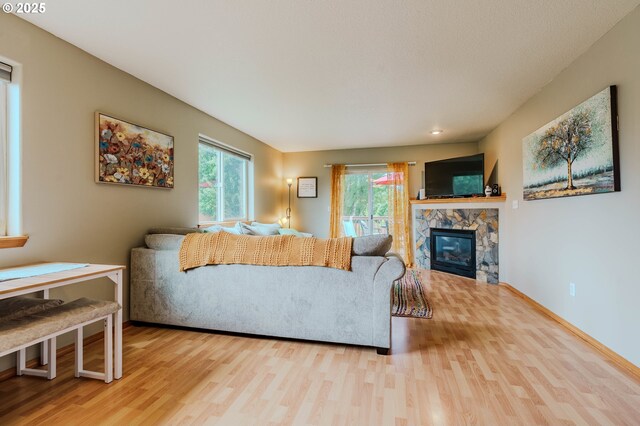 595 Cozy Way, Woodburn, OR 97071 - living room featuring wood finished floors, healthy amount of natural light, and a stone fireplace