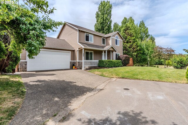 595 Cozy Way, Woodburn, OR 97071 - traditional-style home featuring asphalt driveway, covered porch, stone siding, a garage, and a front lawn