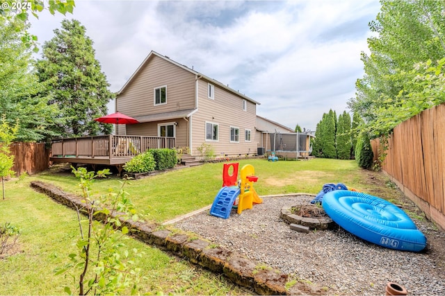 595 Cozy Way, Woodburn, OR 97071 - back of property with a trampoline, a deck, and a fenced backyard