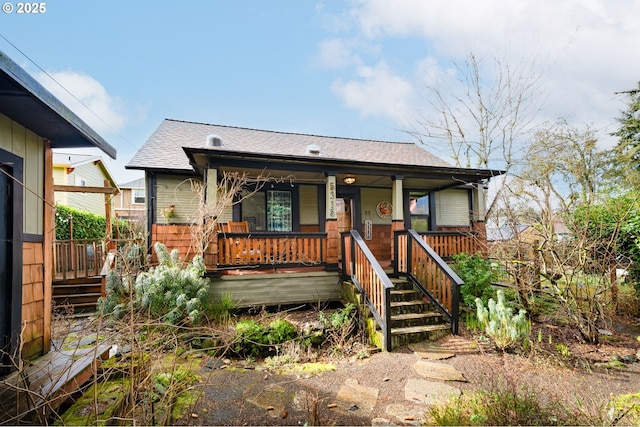 bungalow-style home with a porch and a shingled roof