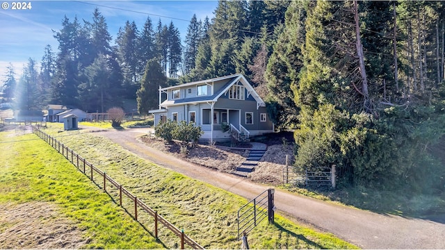 view of front of home featuring fence, driveway, and a porch