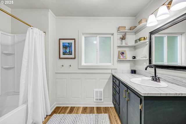 bathroom with wood finished floors, vanity, and shower / bath combo with shower curtain