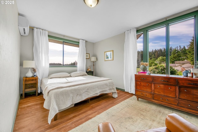 bedroom featuring an AC wall unit and wood finished floors