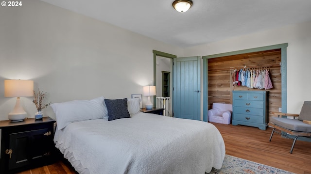 bedroom with wood finished floors and a closet