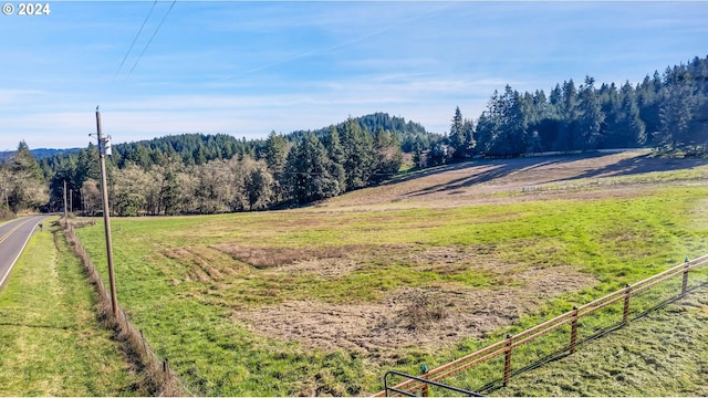 view of yard featuring fence and a wooded view