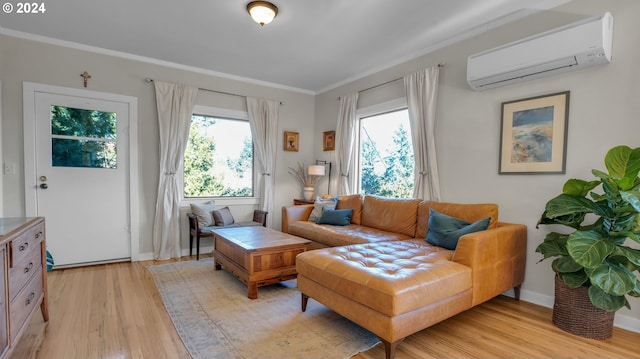 living area with a wall unit AC, healthy amount of natural light, light wood-style floors, ornamental molding, and baseboards