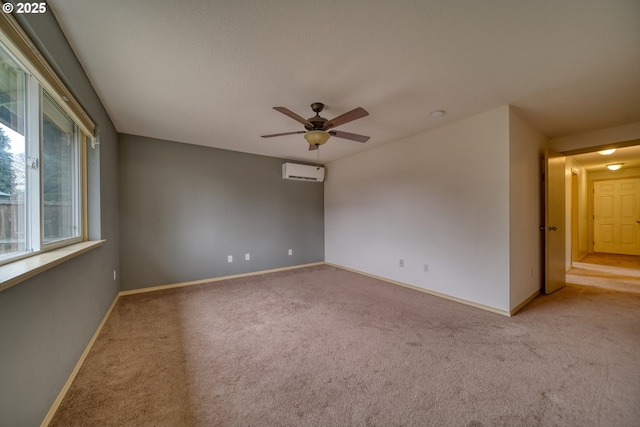 unfurnished room with ceiling fan, baseboards, carpet floors, and a wall mounted AC