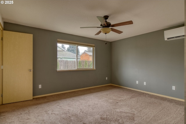 empty room with carpet flooring, a ceiling fan, a wall mounted AC, and baseboards