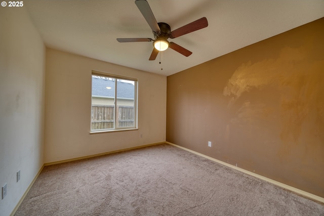 empty room featuring carpet flooring, ceiling fan, and baseboards