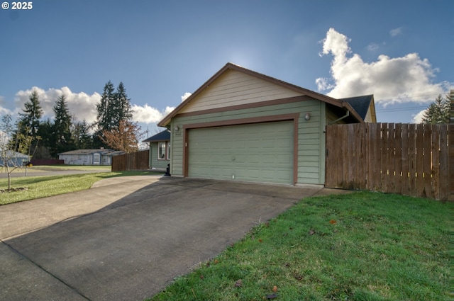 garage featuring concrete driveway and fence