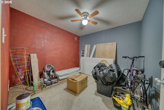 interior space with a textured ceiling, ceiling fan, and unfinished concrete floors