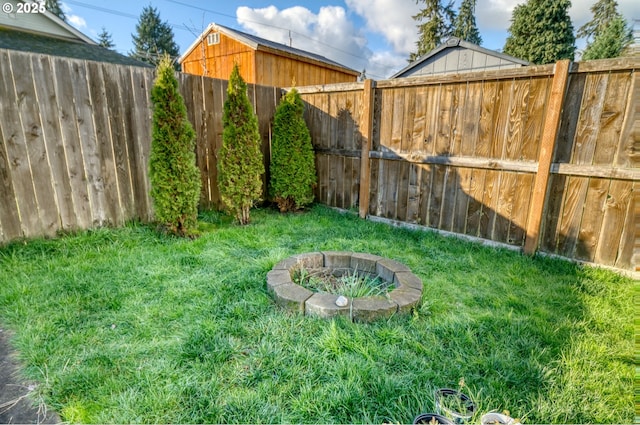 view of yard featuring a fire pit and a fenced backyard