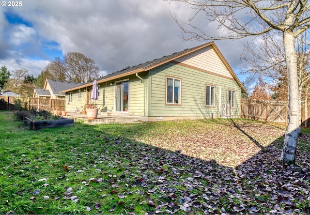 rear view of house with a yard, a patio, and a fenced backyard