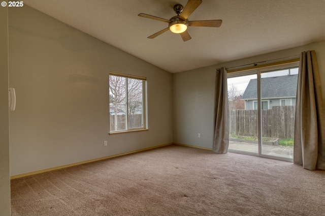 empty room with a wealth of natural light, baseboards, carpet, and lofted ceiling