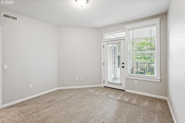 empty room featuring carpet floors, visible vents, and baseboards