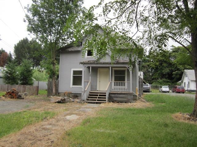 1725 SE Mill St, Roseburg, OR 97470 - view of front facade featuring fence, a front yard, and a porch