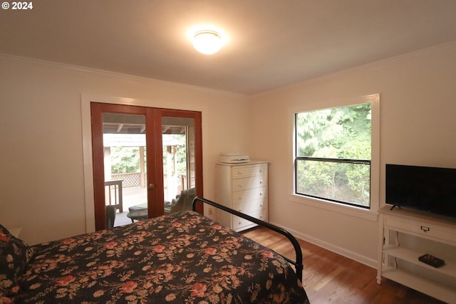 bedroom featuring access to exterior, crown molding, multiple windows, and hardwood / wood-style flooring