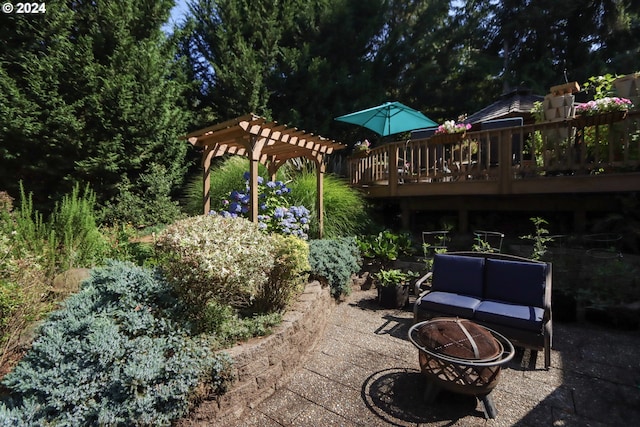 view of patio / terrace featuring a deck and an outdoor living space with a fire pit