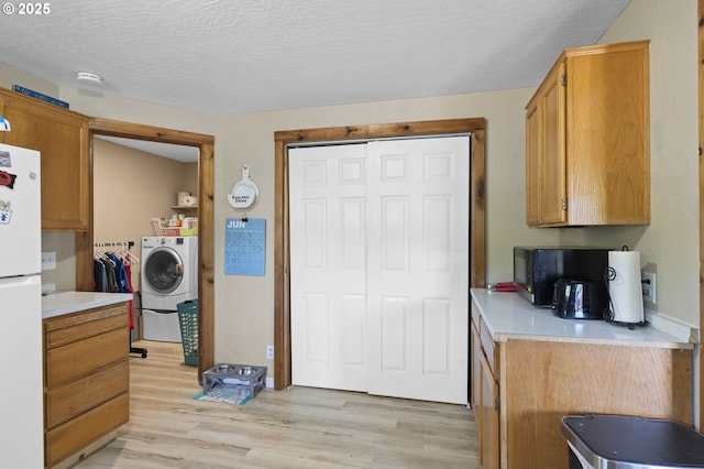 1135 Birch Ave, Cottage Grove, OR 97424 - kitchen with washer / clothes dryer, freestanding refrigerator, light countertops, light wood-type flooring, and a textured ceiling