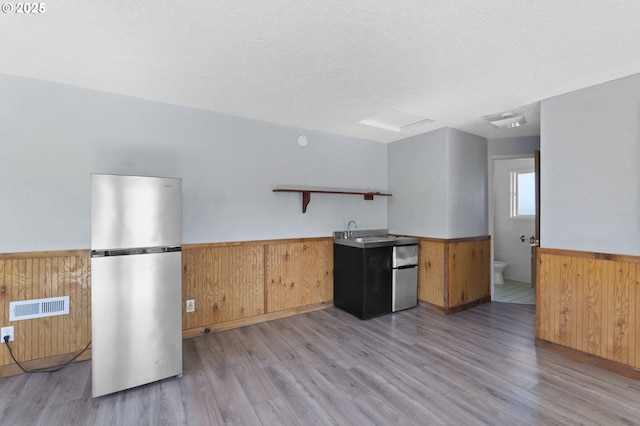 1135 Birch Ave, Cottage Grove, OR 97424 - kitchen with freestanding refrigerator, wainscoting, open shelves, light wood-style flooring, and wooden walls