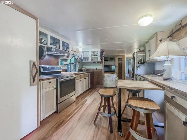 34360 NE Colorado Lake Dr Unit 996, Corvallis, OR 97333 - kitchen featuring appliances with stainless steel finishes, light wood-style flooring, a sink, open shelves, and under cabinet range hood
