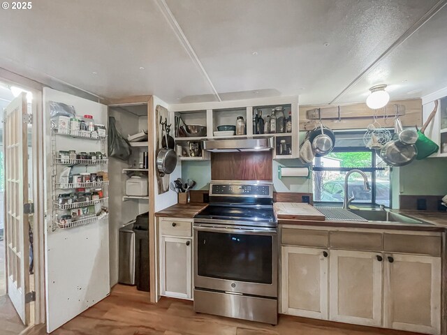 34360 NE Colorado Lake Dr Unit 996, Corvallis, OR 97333 - kitchen with stainless steel electric stove, a sink, wall chimney range hood, light wood-style flooring, and butcher block countertops