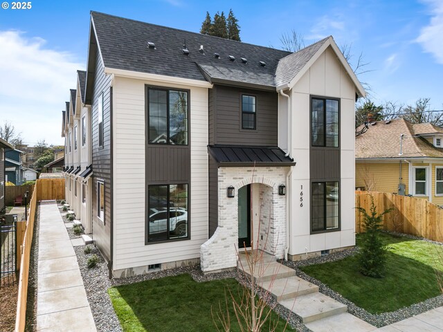 view of front of home with a front yard, fence, and roof with shingles