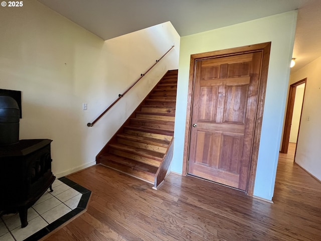 3715 Coho Pl, Cannon Beach, OR 97110 - stairway with a wood stove, wood finished floors, and baseboards