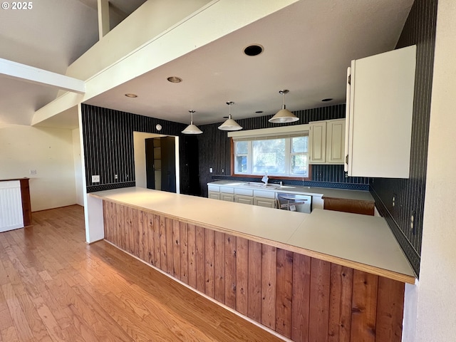 3715 Coho Pl, Cannon Beach, OR 97110 - kitchen featuring dishwasher, light wood-type flooring, pendant lighting, white cabinetry, and a peninsula