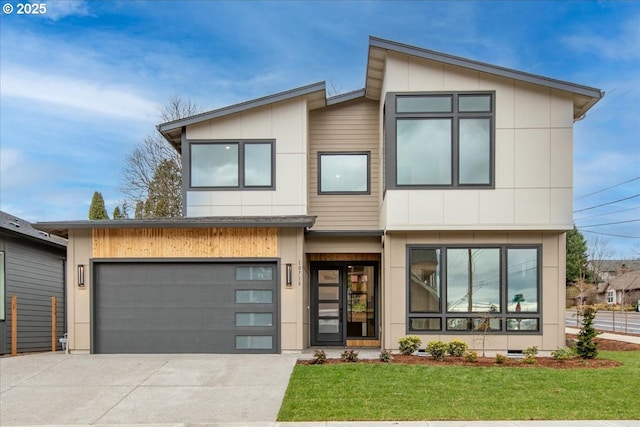 contemporary home with a front lawn, an attached garage, and driveway