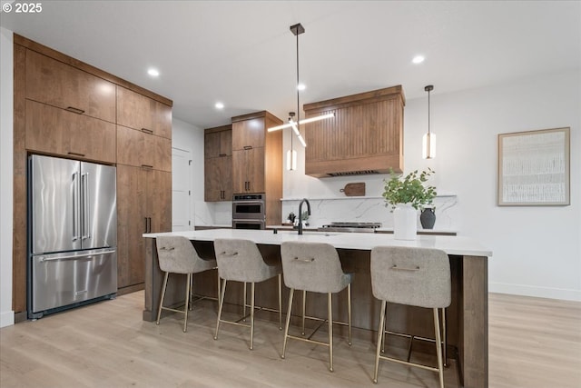 kitchen with a breakfast bar area, stainless steel appliances, light wood-type flooring, and modern cabinets