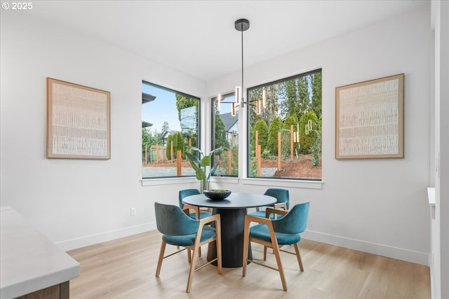 dining space with baseboards and light wood finished floors