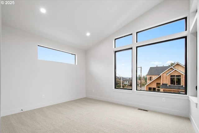 spare room with visible vents, recessed lighting, baseboards, carpet, and lofted ceiling