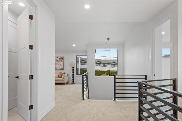 hallway with recessed lighting, an upstairs landing, baseboards, and carpet floors