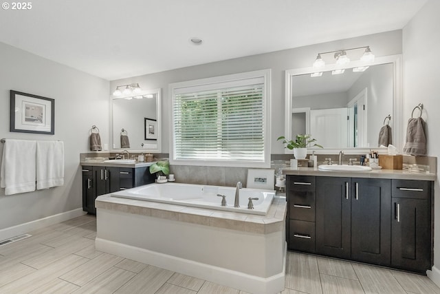 21163 SW Nursery Way, Sherwood, OR 97140 - full bath with two vanities, a garden tub, wood finish floors, and baseboards