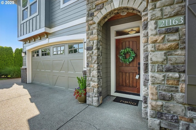 21163 SW Nursery Way, Sherwood, OR 97140 - view of exterior entry with stone siding, a garage, and driveway