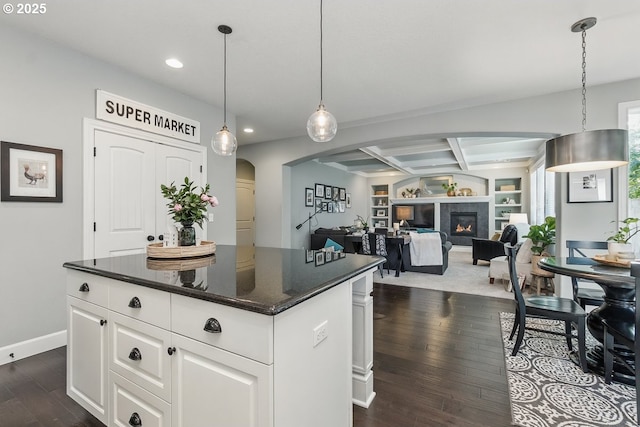 21163 SW Nursery Way, Sherwood, OR 97140 - kitchen with recessed lighting, dark wood-style flooring, a kitchen island, arched walkways, and white cabinets