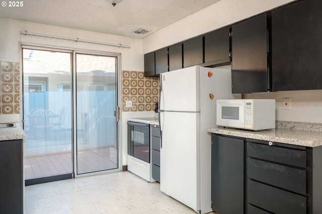 10904 SW 62nd Pl, Portland, OR 97219 - kitchen featuring white appliances, light countertops, dark cabinetry, a textured ceiling, and light floors