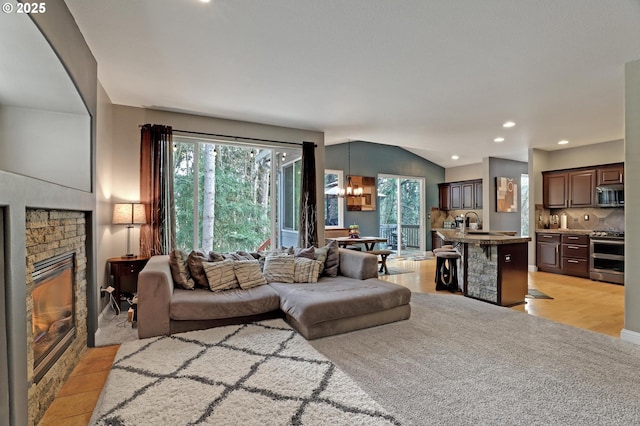 living room featuring a healthy amount of sunlight, sink, a notable chandelier, and light hardwood / wood-style flooring