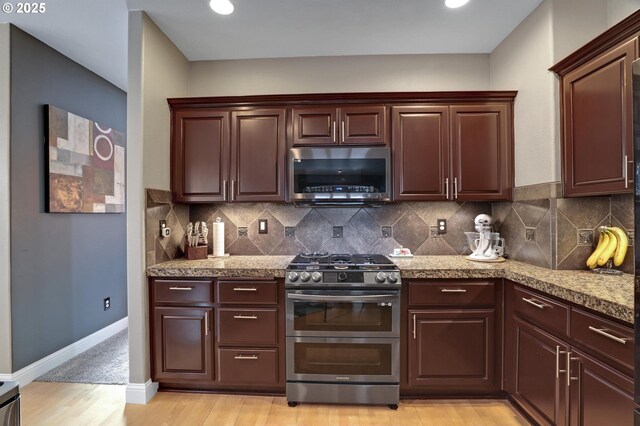 1044 N 26th Ter, Cornelius, OR 97113 - kitchen featuring stainless steel appliances, decorative backsplash, light wood-type flooring, and baseboards