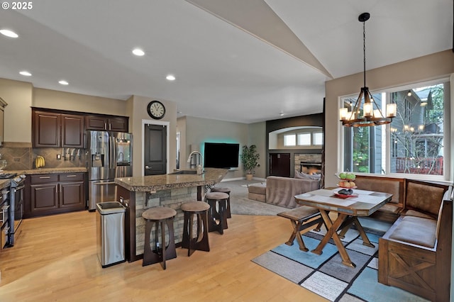 1044 N 26th Ter, Cornelius, OR 97113 - dining room with light wood-style flooring, a chandelier, recessed lighting, lofted ceiling, and a stone fireplace