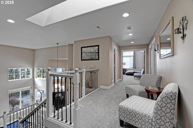 hall featuring light carpet and a skylight