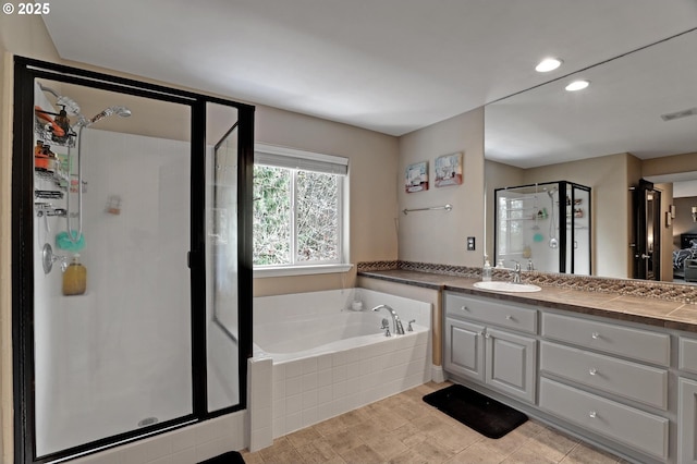 bathroom with vanity and separate shower and tub